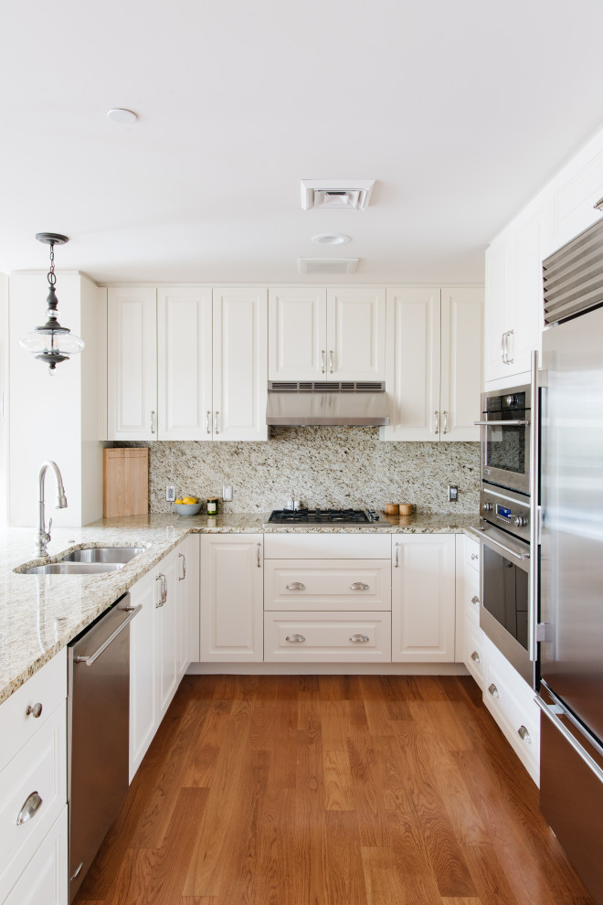 Foto på ett mellanstort amerikanskt beige kök, med vita skåp, granitbänkskiva, beige stänkskydd, rostfria vitvaror och mellanmörkt trägolv