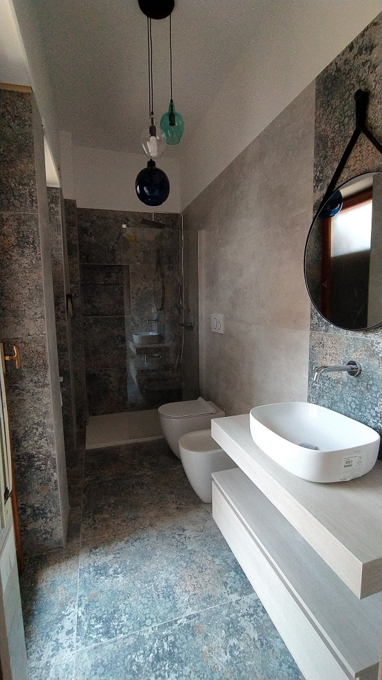 Cette image montre une salle de bain principale design de taille moyenne avec un placard à porte plane, des portes de placard beiges, une douche ouverte, WC séparés, un carrelage multicolore, des carreaux de porcelaine, un mur blanc, un sol en carrelage de porcelaine, une vasque, un plan de toilette en stratifié, un sol multicolore, un plan de toilette beige, meuble simple vasque et meuble-lavabo suspendu.