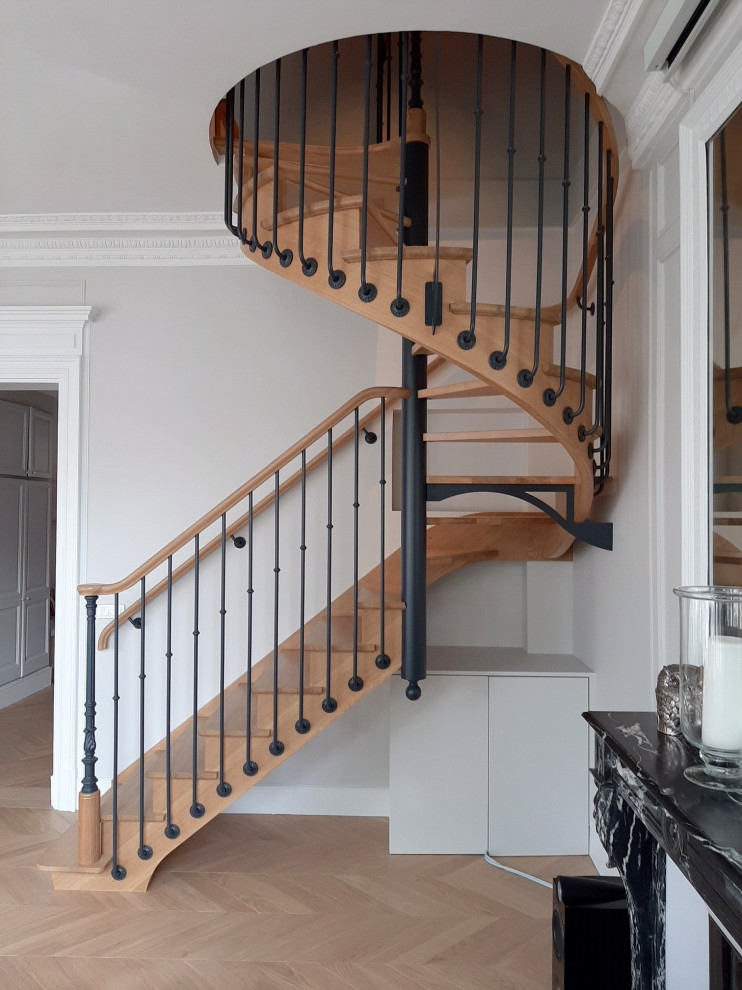 Inspiration for a mid-sized transitional wood spiral staircase in Paris with mixed railing and wood risers.