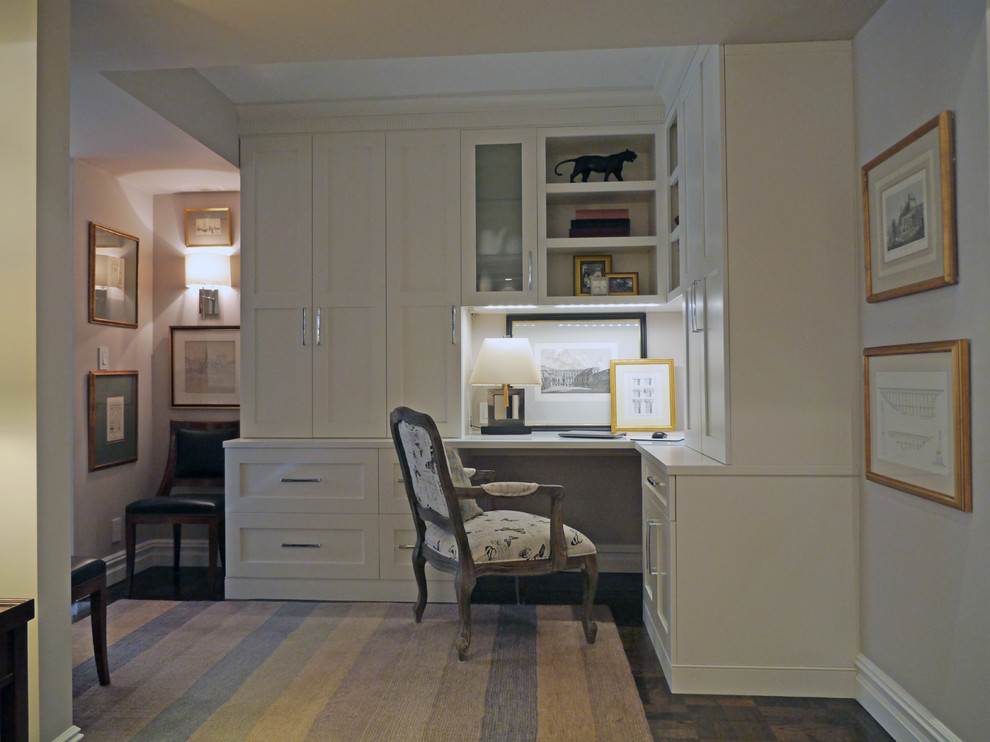 This is an example of a small contemporary home office in New York with beige walls and a built-in desk.