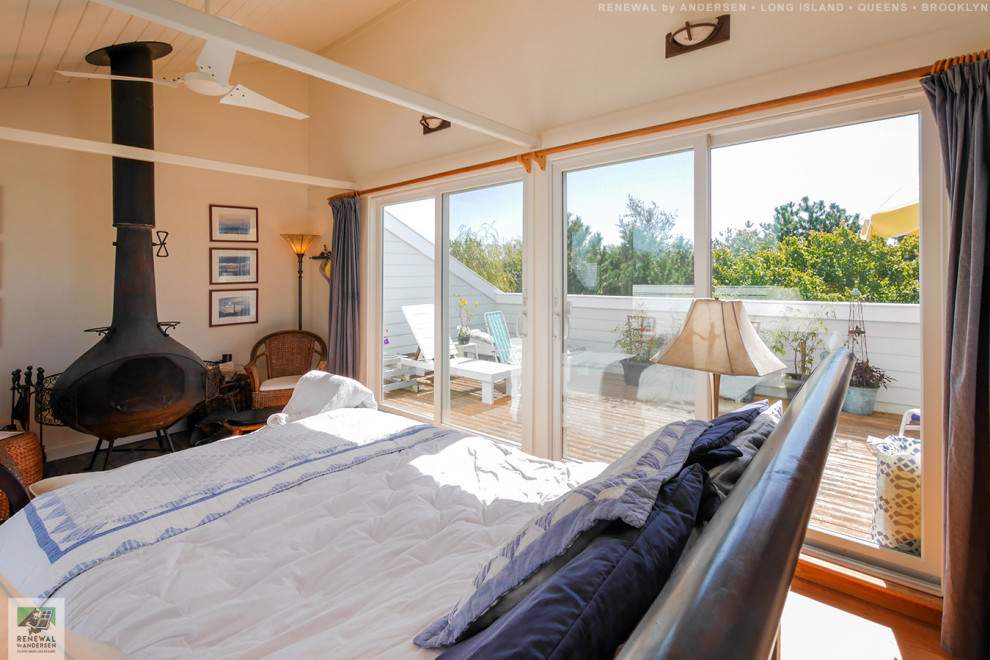 Idee per una camera da letto stile loft di medie dimensioni con pareti beige, parquet chiaro, stufa a legna e soffitto in perlinato
