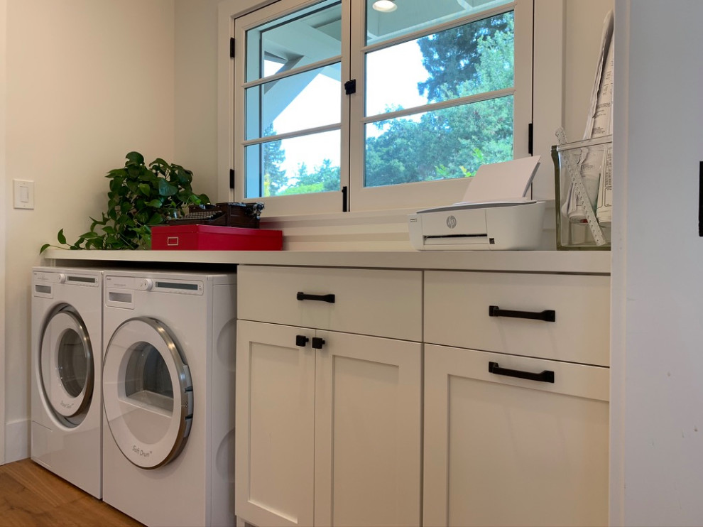 Utility room - small craftsman single-wall medium tone wood floor and brown floor utility room idea in San Francisco with shaker cabinets, white cabinets, wood countertops, white walls, a side-by-side washer/dryer and white countertops