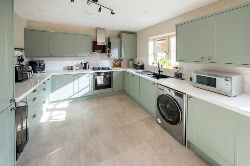 Large u-shaped ceramic tile and beige floor eat-in kitchen photo with shaker cabinets, green cabinets, quartz countertops, white backsplash, stainless steel appliances, no island and white countertops