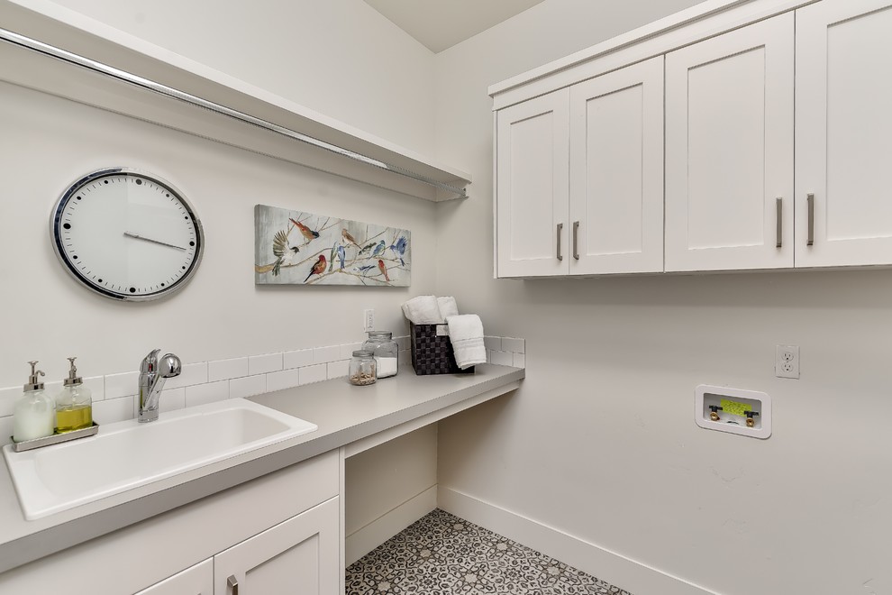 Country laundry room in Boise with a drop-in sink, shaker cabinets, white cabinets, laminate benchtops, white walls, vinyl floors and a side-by-side washer and dryer.