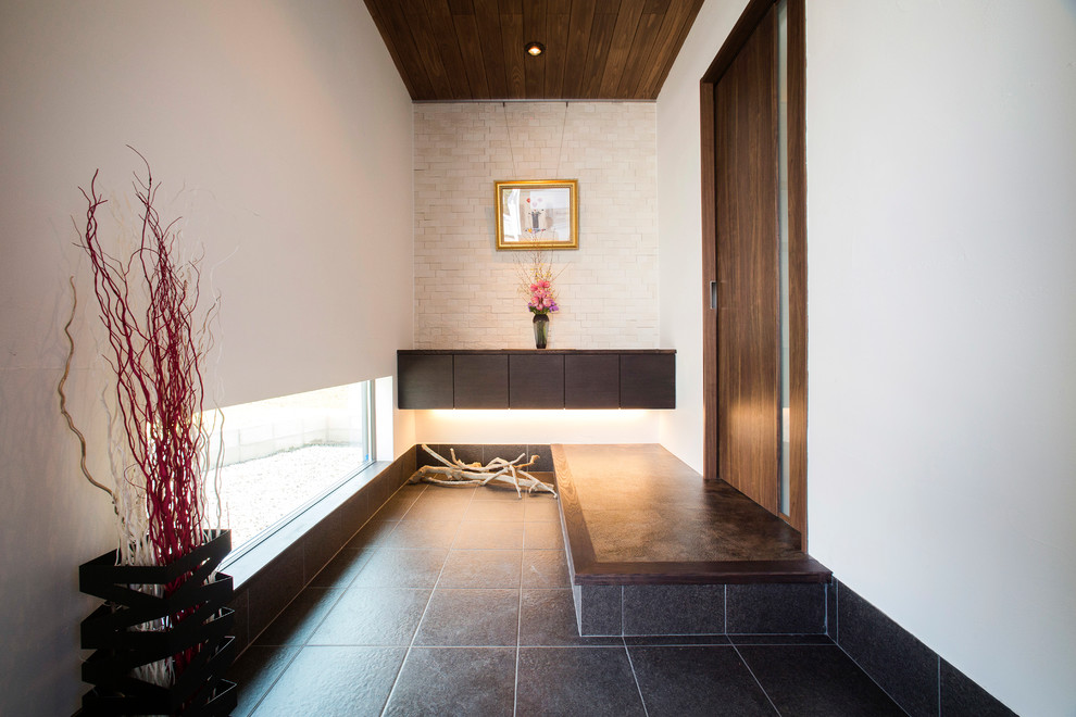 Contemporary entryway in Other with white walls and grey floor.
