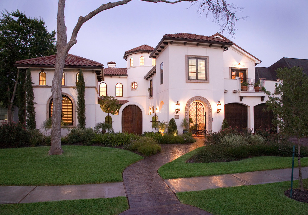 Inspiration for a mediterranean three-storey white exterior in Houston with a hip roof.