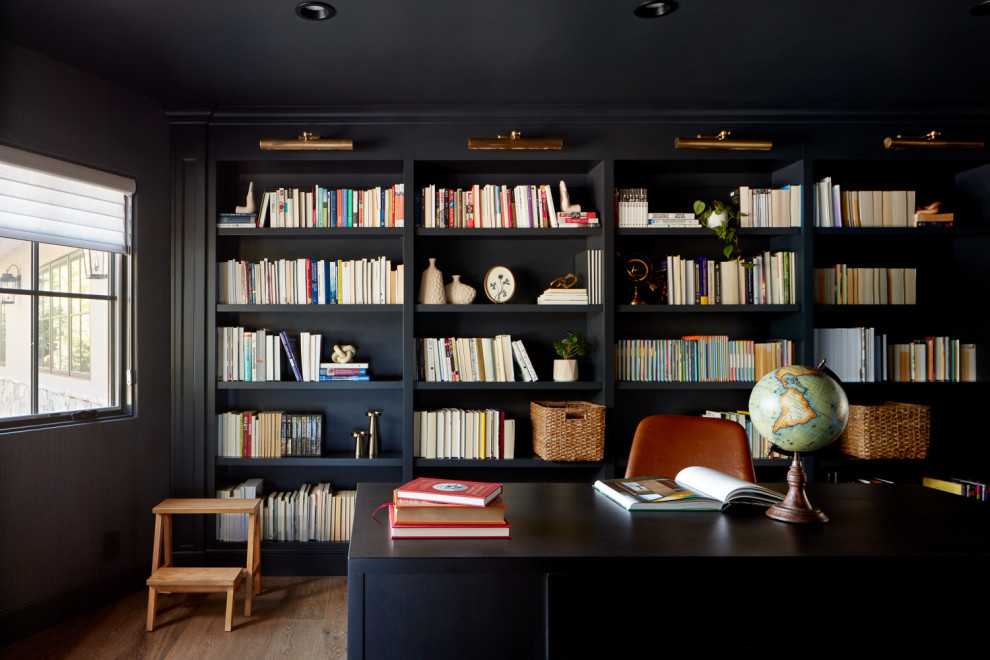 Inspiration for a large arts and crafts study room in San Francisco with black walls, medium hardwood floors, a freestanding desk and brown floor.