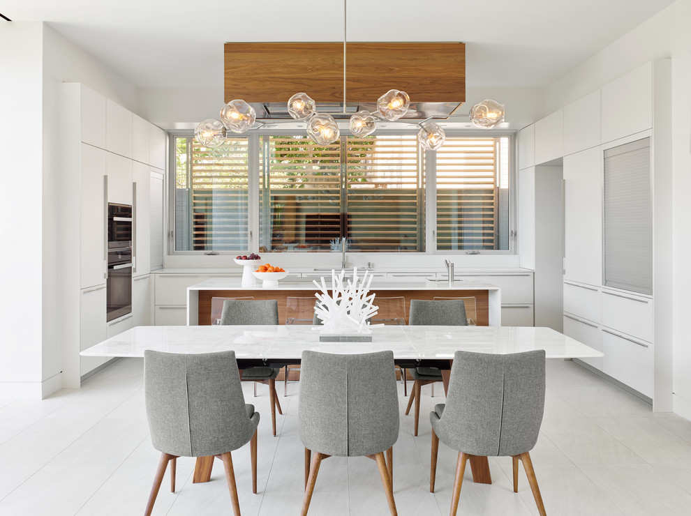 Inspiration for a contemporary galley eat-in kitchen in Los Angeles with an undermount sink, flat-panel cabinets, white cabinets, stainless steel appliances, with island and white floor.