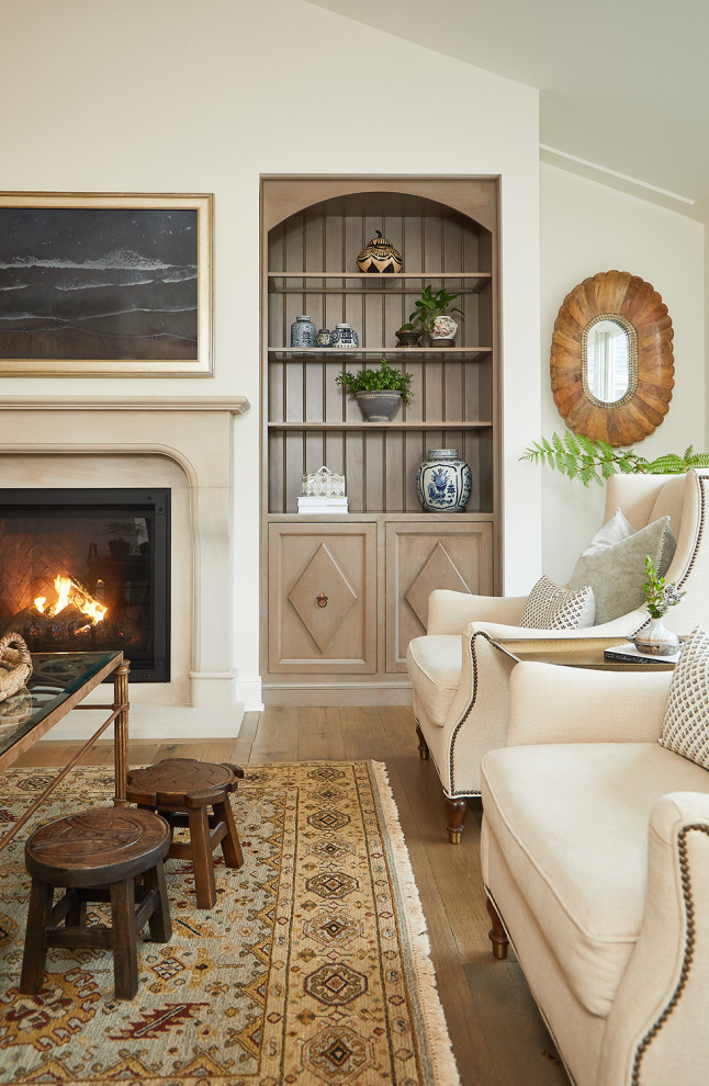Inspiration for a large formal enclosed living room in Grand Rapids with white walls, light hardwood flooring, a standard fireplace, a stone fireplace surround, brown floors and a vaulted ceiling.