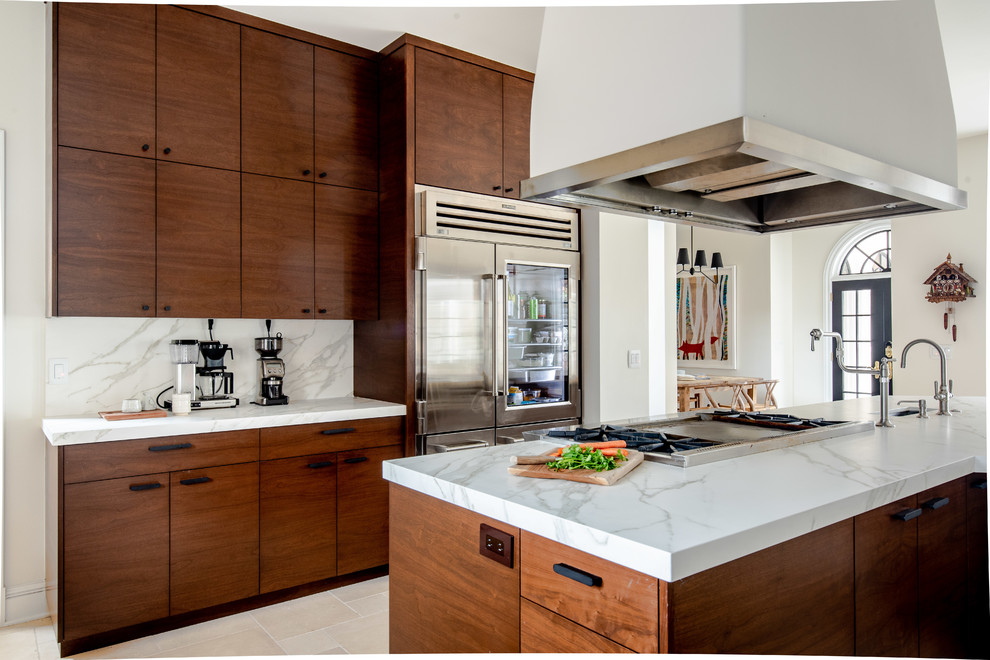 Design ideas for an expansive contemporary u-shaped kitchen pantry in Denver with a farmhouse sink, dark wood cabinets, beige splashback, stainless steel appliances, a peninsula, beige floor, flat-panel cabinets, marble benchtops, stone tile splashback, limestone floors and white benchtop.