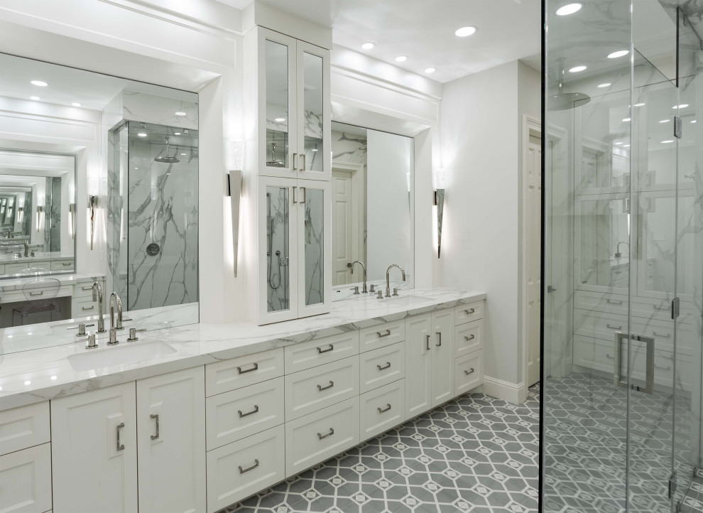 Huge transitional master white tile and stone slab concrete floor, gray floor and double-sink walk-in shower photo in Houston with furniture-like cabinets, white cabinets, a wall-mount toilet, white walls, an undermount sink, marble countertops, a hinged shower door, white countertops, a niche and a built-in vanity