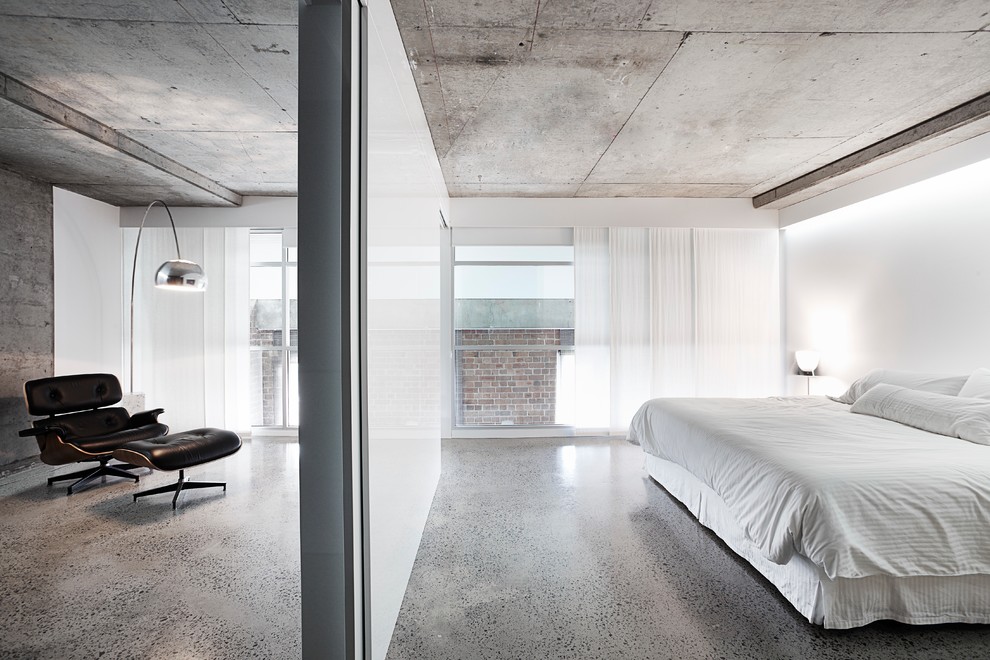 This is an example of a contemporary bedroom in Sydney with white walls, concrete floors and grey floor.