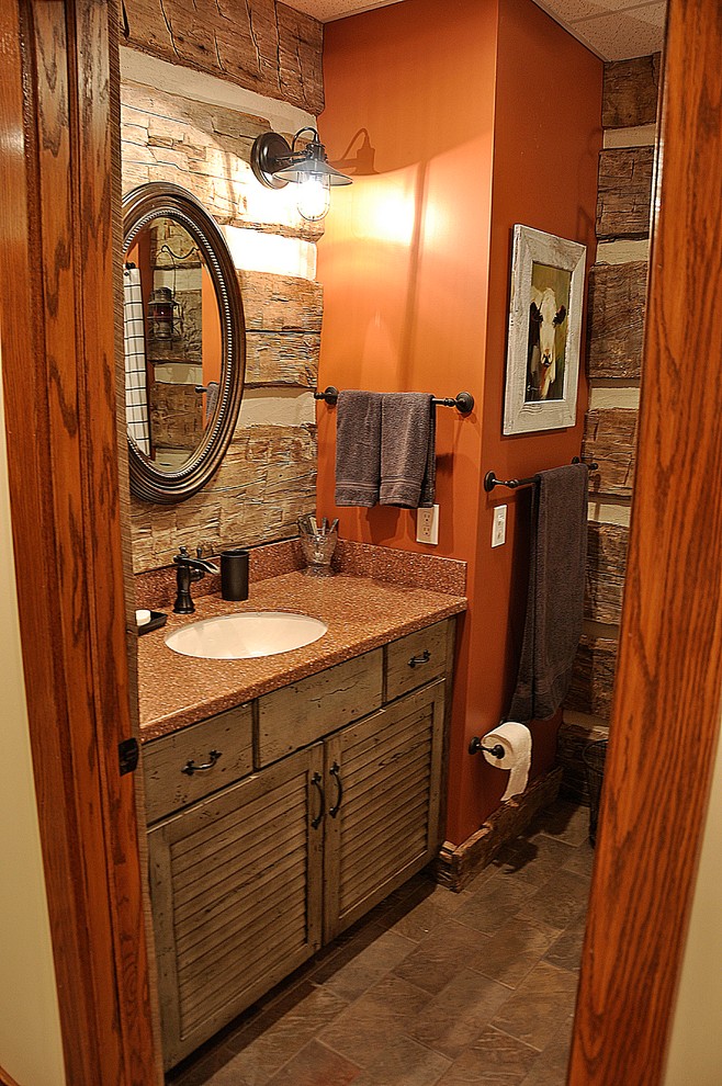 This is an example of a country bathroom in Nashville with an undermount sink, louvered cabinets, distressed cabinets and solid surface benchtops.