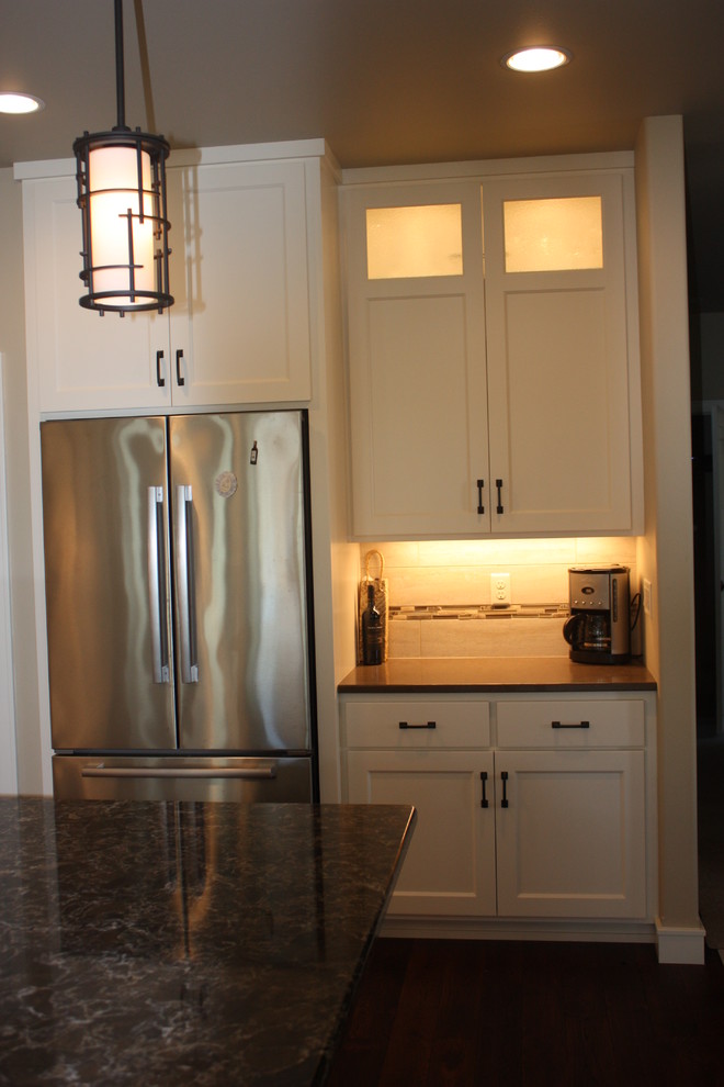 Open concept kitchen - mid-sized transitional l-shaped dark wood floor open concept kitchen idea with an undermount sink, recessed-panel cabinets, white cabinets, quartz countertops, beige backsplash, ceramic backsplash, stainless steel appliances and an island