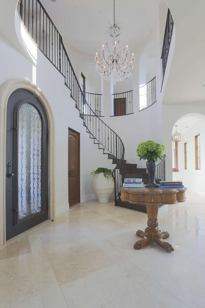 Photo of a large mediterranean foyer in San Diego with grey walls, marble floors, a single front door and a black front door.