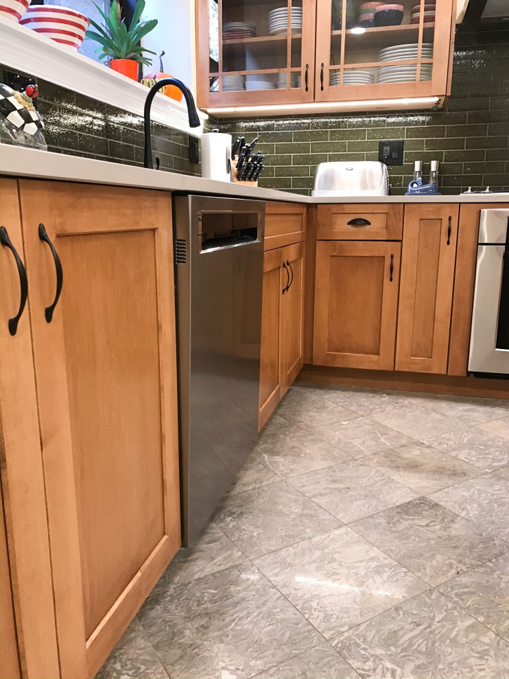Eat-in kitchen - mid-sized transitional l-shaped eat-in kitchen idea in Chicago with an undermount sink, shaker cabinets, brown cabinets, green backsplash, stainless steel appliances, an island and gray countertops