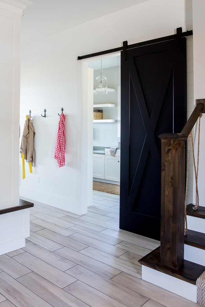 Example of a mid-sized transitional porcelain tile and beige floor mudroom design in Phoenix with white walls