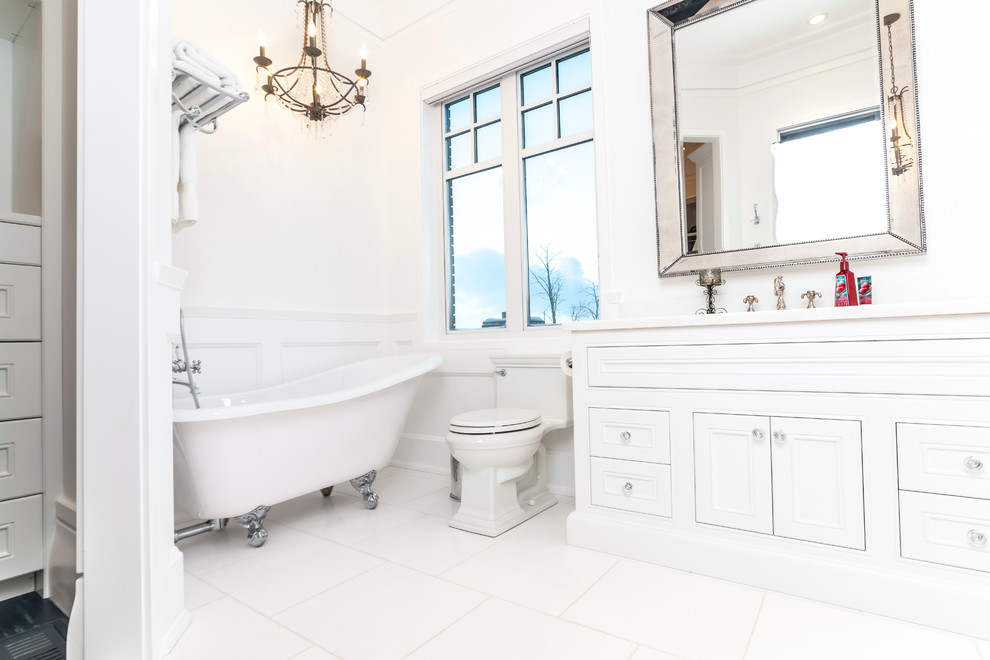 Large contemporary master bathroom in Edmonton with a drop-in sink, beaded inset cabinets, solid surface benchtops, a claw-foot tub, white tile, ceramic tile, white walls and ceramic floors.