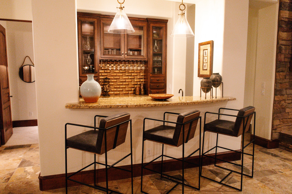 Huge travertine floor, beige floor and tray ceiling kitchen photo in Phoenix with a double-bowl sink, glass-front cabinets, dark wood cabinets, granite countertops, gray backsplash, stone slab backsplash, stainless steel appliances, an island and gray countertops