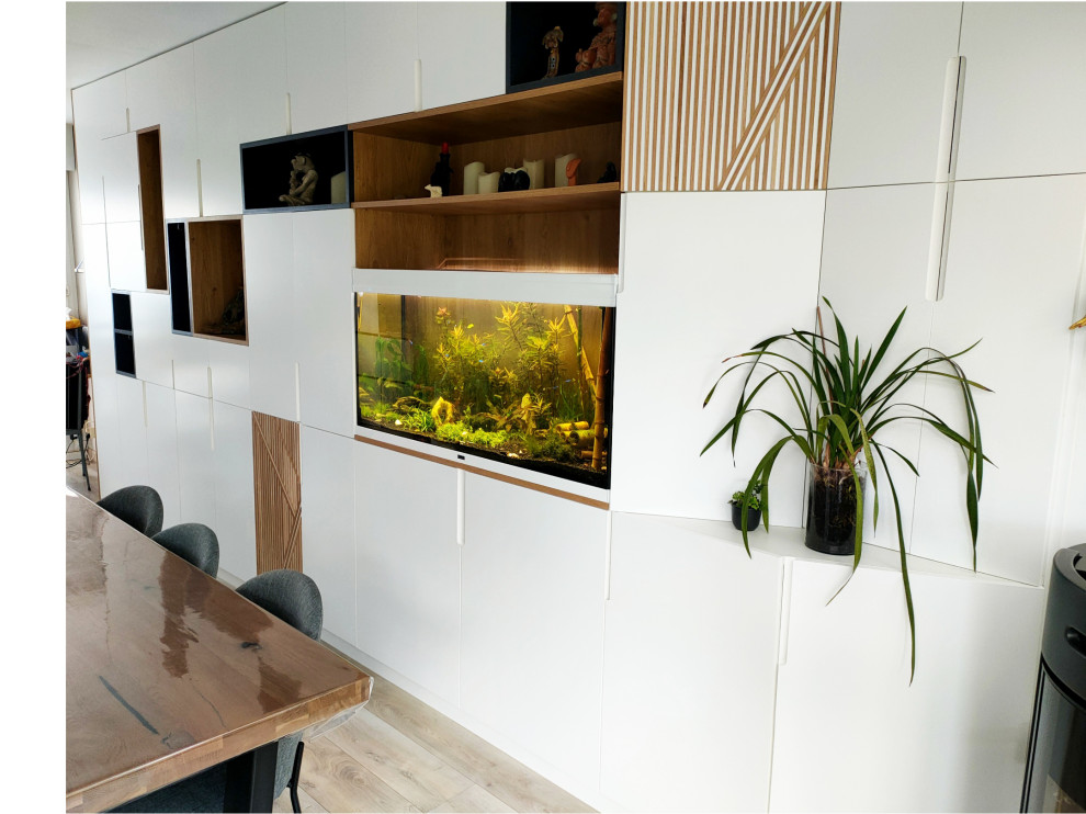 Idée de décoration pour une salle à manger ouverte sur le salon design de taille moyenne avec un mur blanc, parquet clair, un poêle à bois et un sol gris.