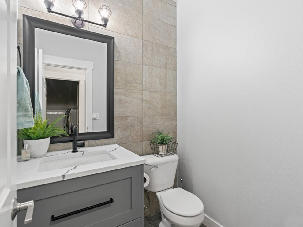 Cette image montre une petite salle d'eau minimaliste avec un placard à porte affleurante, des portes de placard grises, WC à poser, un carrelage beige, des carreaux de céramique, un mur gris, carreaux de ciment au sol, un lavabo encastré, un plan de toilette en marbre, un sol noir, un plan de toilette blanc, meuble simple vasque, meuble-lavabo sur pied et un plafond en papier peint.