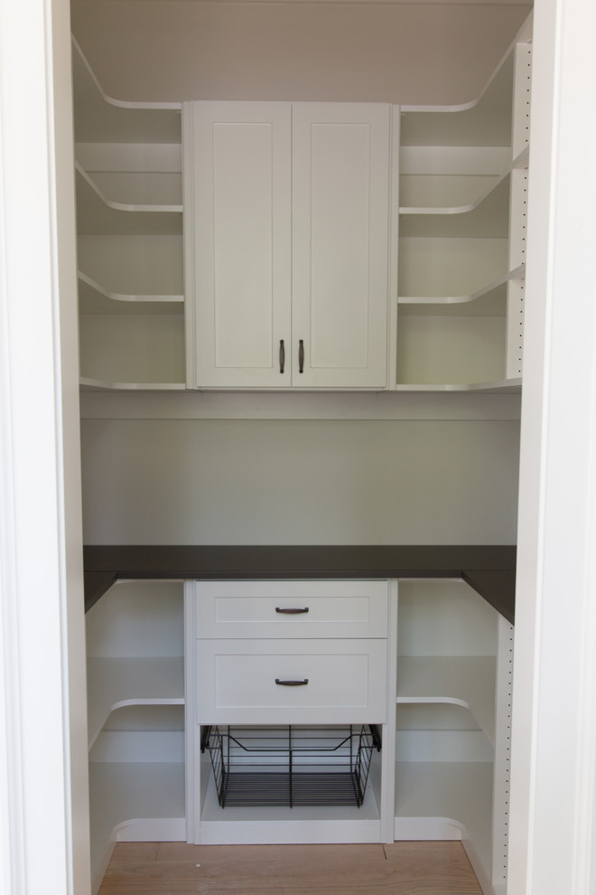 This is an example of a mid-sized arts and crafts u-shaped kitchen pantry in Atlanta with shaker cabinets, white cabinets, laminate benchtops, light hardwood floors, no island, brown floor and brown benchtop.