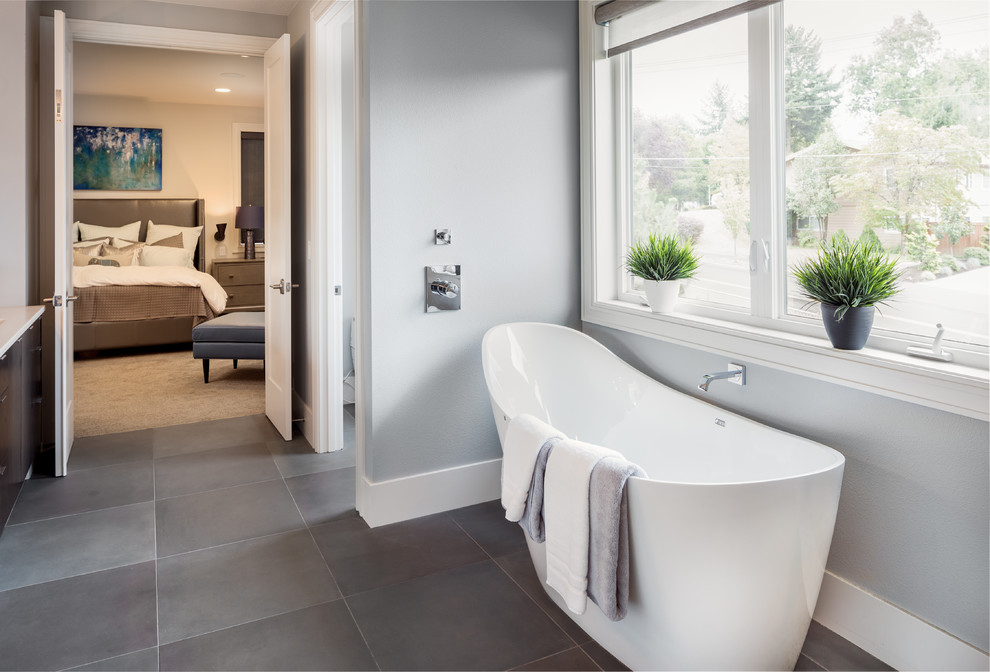 Design ideas for a large contemporary master bathroom in Portland with an undermount sink, flat-panel cabinets, dark wood cabinets, a freestanding tub, a curbless shower, a wall-mount toilet, stone tile and beige walls.