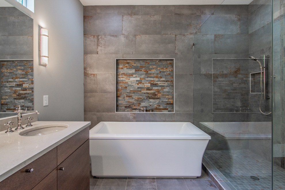 Large modern master bathroom in Atlanta with flat-panel cabinets, brown cabinets, a freestanding tub, a corner shower, a two-piece toilet, gray tile, porcelain tile, grey walls, porcelain floors, an undermount sink, engineered quartz benchtops, multi-coloured floor, a hinged shower door and grey benchtops.