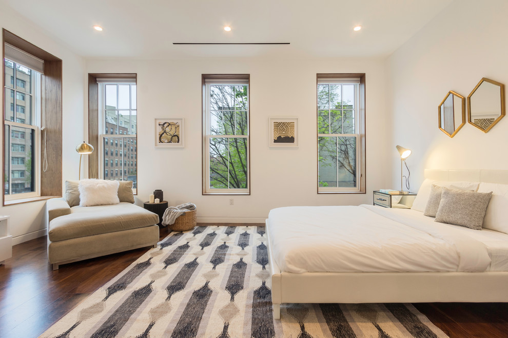 This is an example of an expansive contemporary master bedroom in New York with white walls, medium hardwood floors, no fireplace and brown floor.