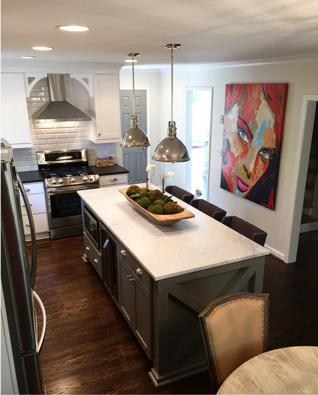 Mid-sized transitional l-shaped dark wood floor and brown floor eat-in kitchen photo in Birmingham with shaker cabinets, white cabinets, marble countertops, white backsplash, subway tile backsplash, stainless steel appliances and an island