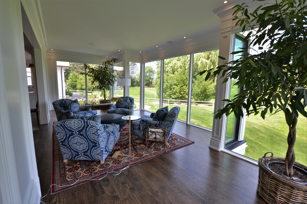 This is an example of a traditional sunroom in Toronto with dark hardwood floors, no fireplace, a glass ceiling and brown floor.