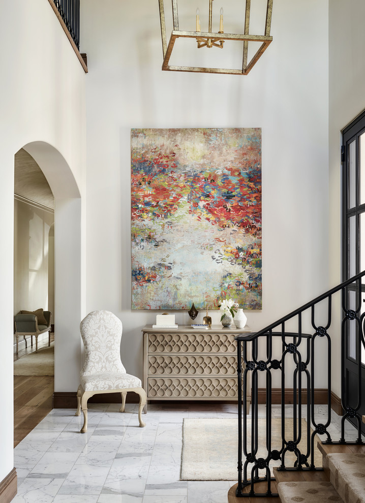 Inspiration for a traditional entryway in Los Angeles with white walls, marble floors and white floor.
