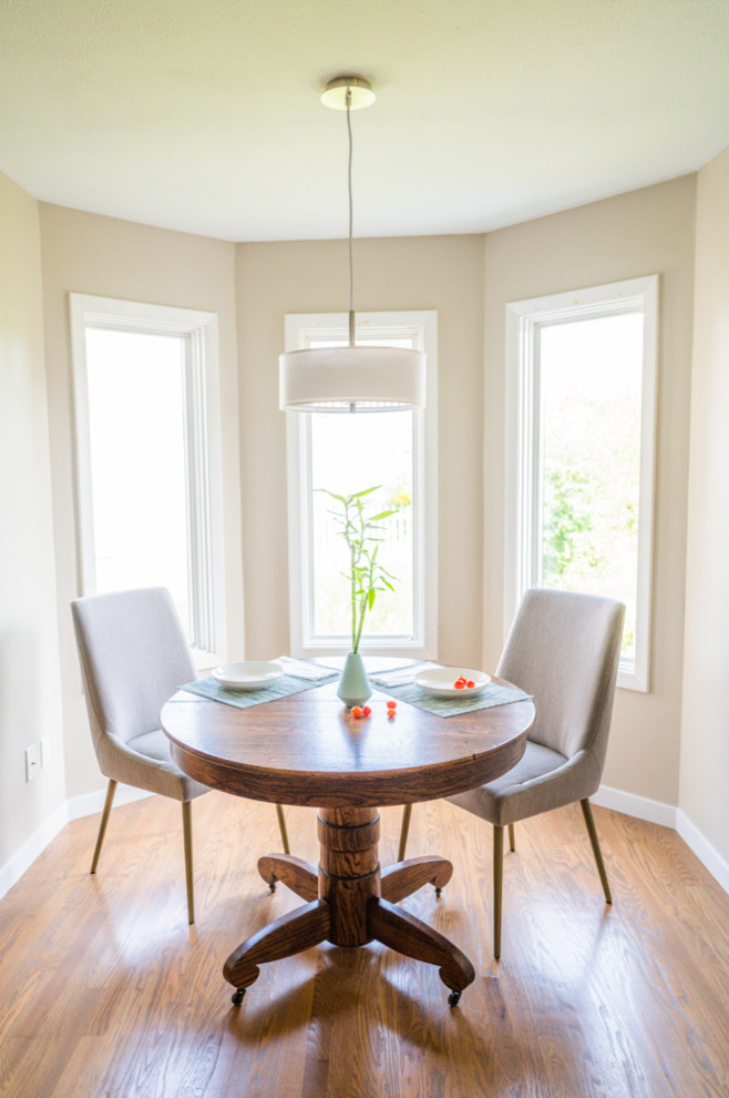 This is an example of a mid-sized modern separate dining room in Cedar Rapids with medium hardwood floors, beige walls and brown floor.