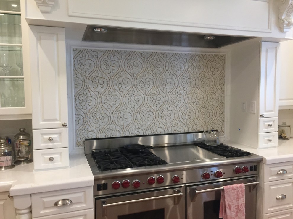 Inspiration for a large mediterranean single-wall enclosed kitchen remodel with a double-bowl sink, marble backsplash and stainless steel appliances