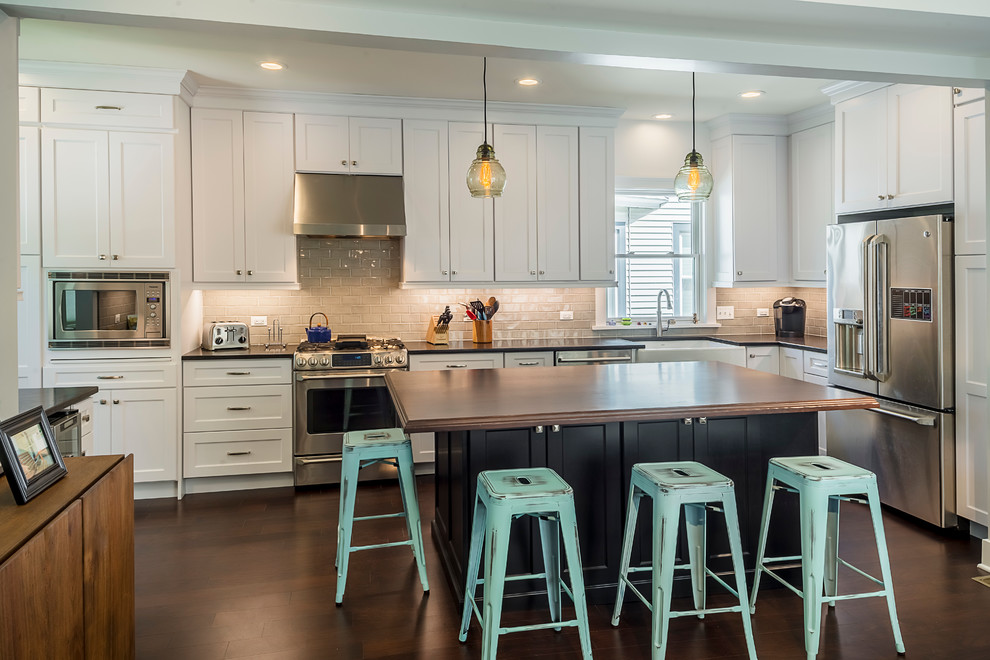 Eat-in kitchen - mid-sized transitional l-shaped dark wood floor eat-in kitchen idea in Chicago with a farmhouse sink, recessed-panel cabinets, white cabinets, laminate countertops, subway tile backsplash, stainless steel appliances and an island