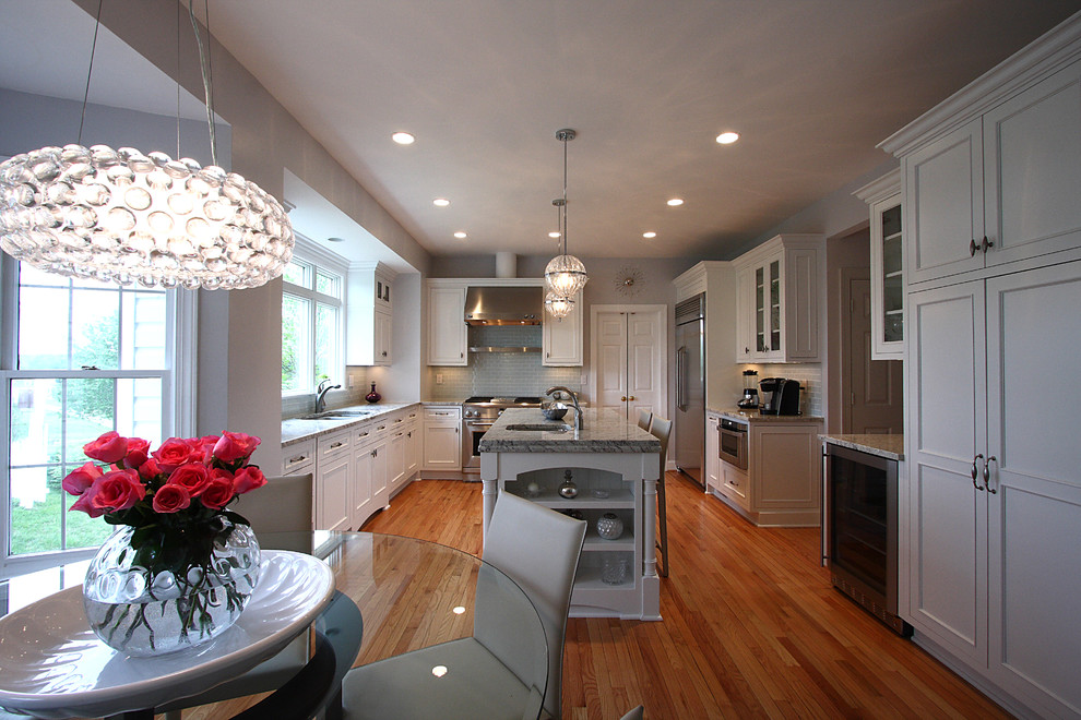 Photo of a traditional u-shaped eat-in kitchen in DC Metro with recessed-panel cabinets and white cabinets.