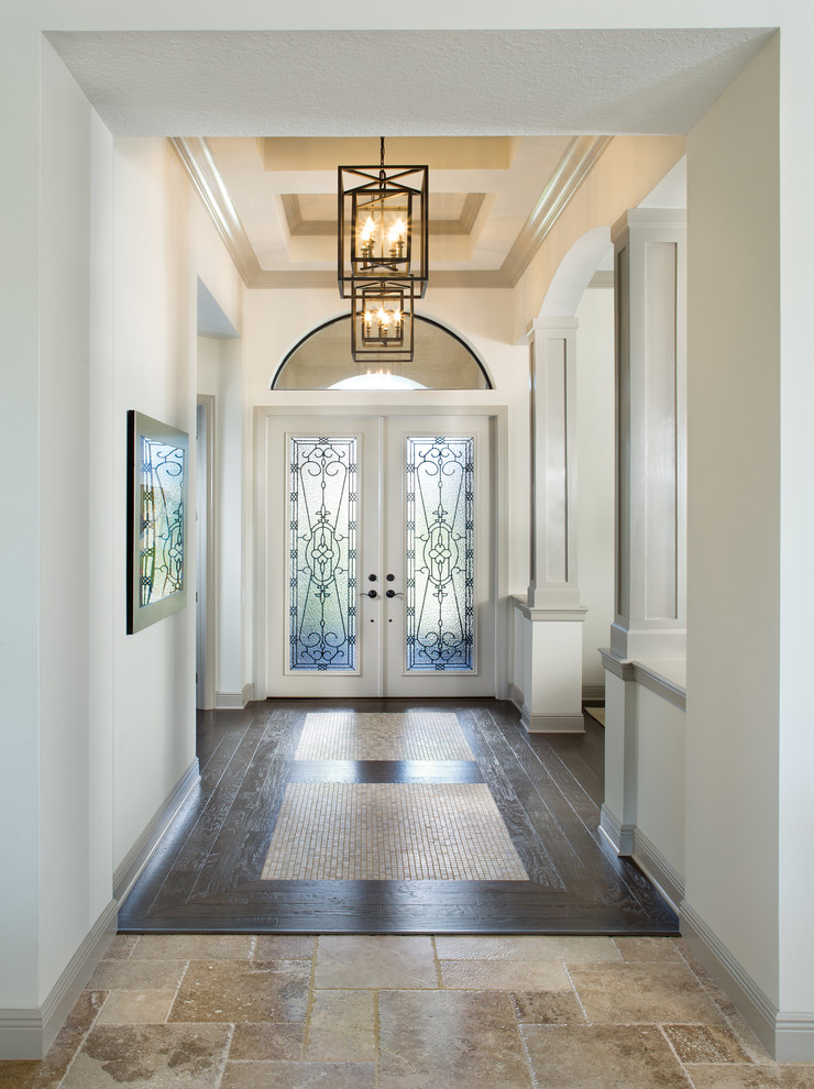 This is an example of a traditional entryway in Tampa with a double front door, a white front door, dark hardwood floors and beige walls.