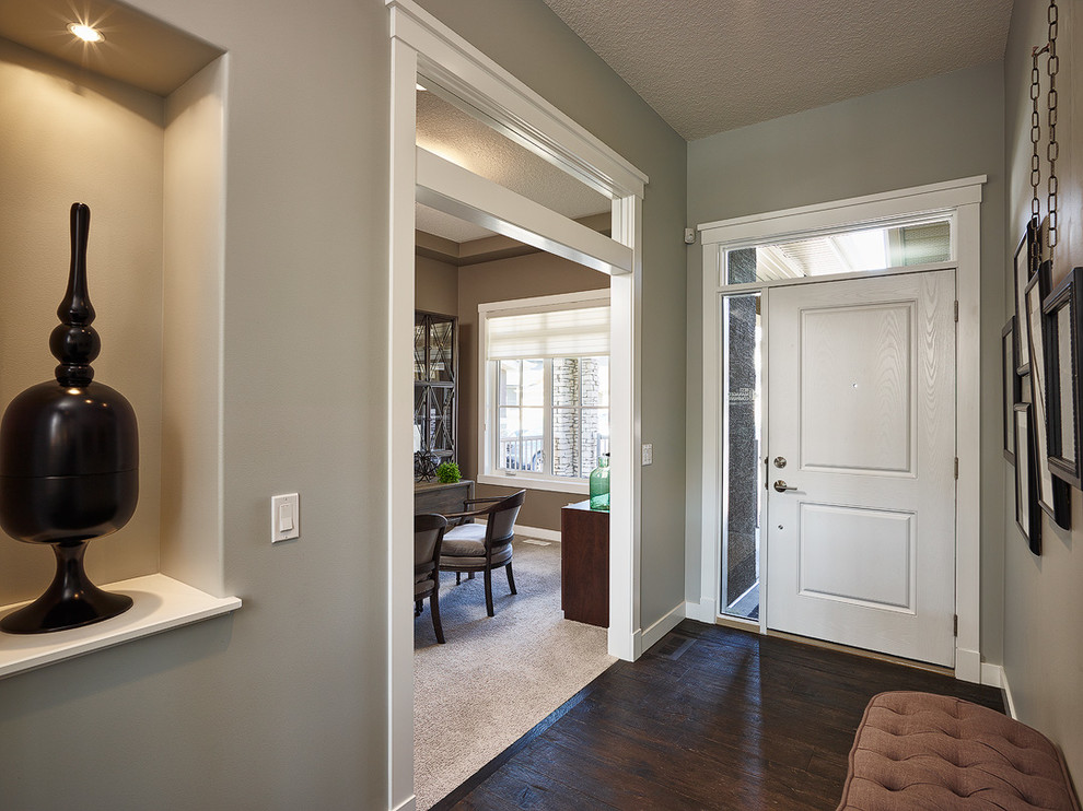 Inspiration for a mid-sized transitional dark wood floor front door remodel in Calgary with gray walls and a white front door