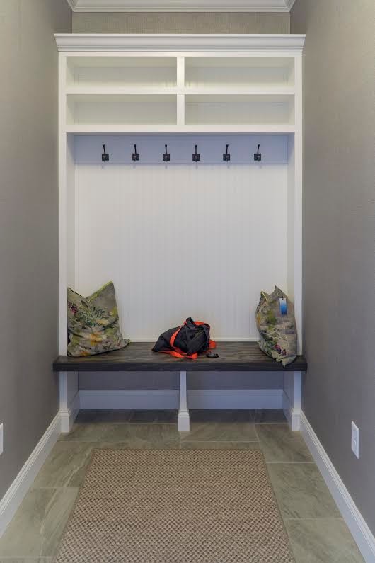 Design ideas for a mid-sized country mudroom in New York with grey walls, porcelain floors and grey floor.
