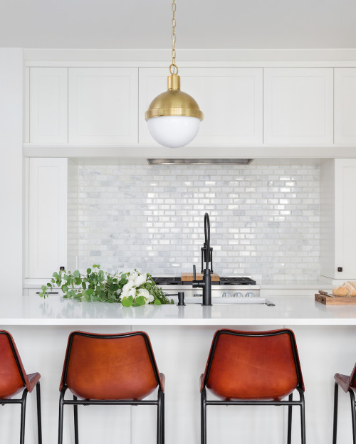 Stacked brown kitchen cabinets flank a black range hood mounted to white  subway backsplash tiles over a stai…