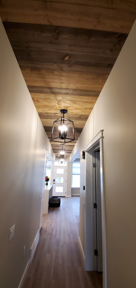 На фото: коридор среднего размера в стиле кантри с белыми стенами, полом из винила, коричневым полом и деревянным потолком