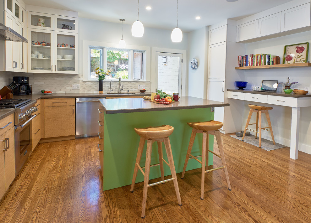 Mid-sized eclectic l-shaped eat-in kitchen in San Francisco with an undermount sink, flat-panel cabinets, light wood cabinets, quartz benchtops, white splashback, ceramic splashback, stainless steel appliances, medium hardwood floors, with island, brown floor and grey benchtop.