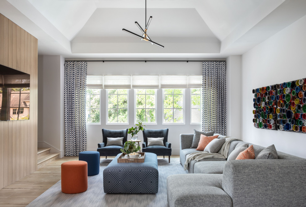 Aménagement d'une grande salle de séjour classique avec un mur gris, parquet clair, un sol marron et un plafond voûté.