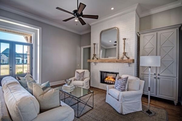 Mid-sized traditional formal open concept living room in Jackson with grey walls, medium hardwood floors, a standard fireplace, a brick fireplace surround, no tv and brown floor.