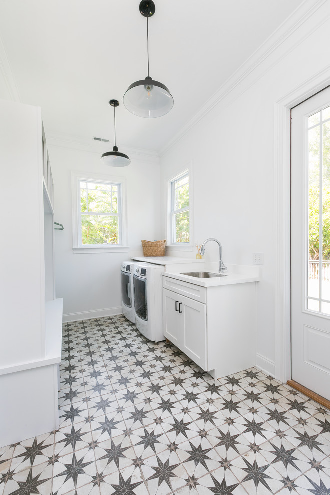 Large country utility room in Charleston with an undermount sink, white cabinets, quartz benchtops, white walls, concrete floors and a side-by-side washer and dryer.