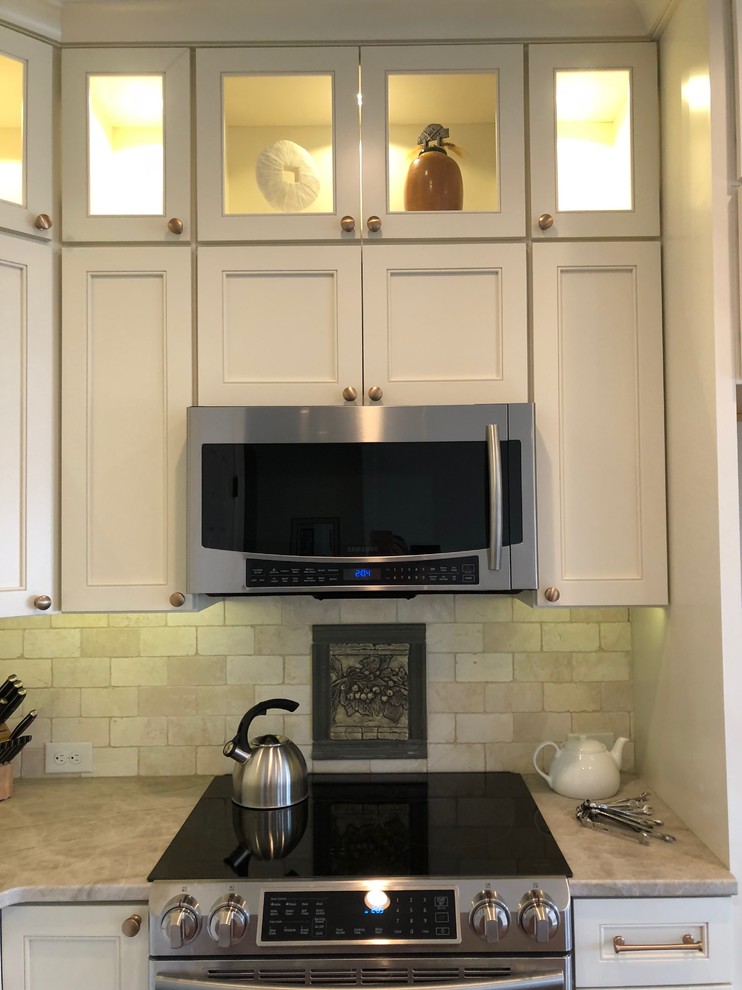 Example of a large transitional dark wood floor and brown floor open concept kitchen design in Omaha with an undermount sink, recessed-panel cabinets, beige cabinets, quartz countertops, beige backsplash, stone tile backsplash, stainless steel appliances, an island and beige countertops