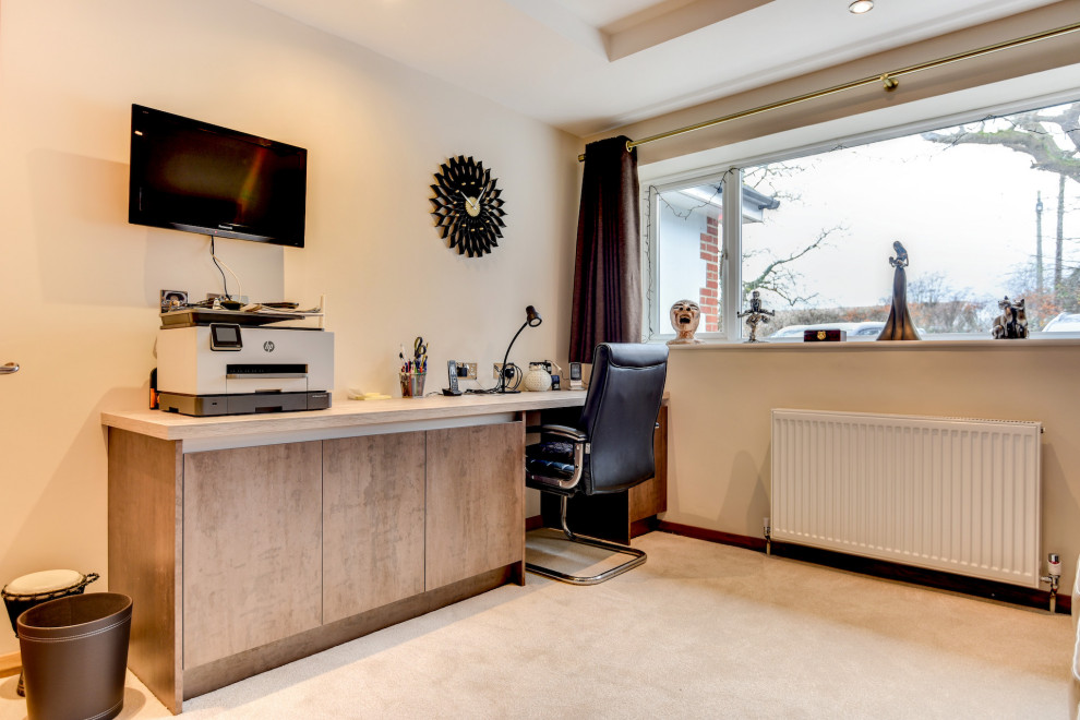 Modelo de despacho minimalista de tamaño medio con paredes beige, moqueta, escritorio empotrado, suelo beige y bandeja