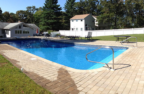 Example of a large backyard stone and custom-shaped pool design in Boston