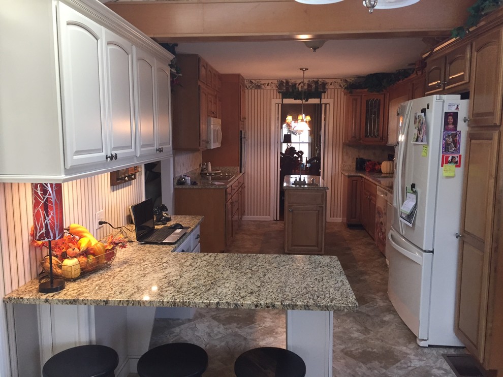 Example of a small transitional l-shaped eat-in kitchen design with raised-panel cabinets, beige cabinets, granite countertops and a peninsula