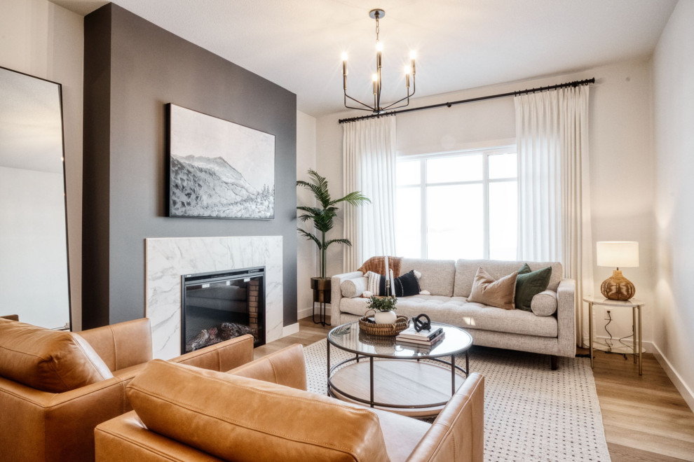 This is an example of a mid-sized formal open concept living room in Edmonton with black walls, laminate floors, a standard fireplace, a tile fireplace surround and beige floor.
